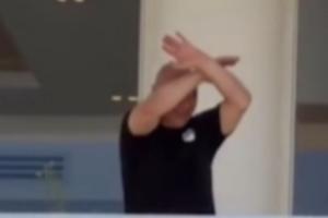 埃及主帅哈桑回国后挥手向现场球迷致意，随后再次做出交叉手势配图